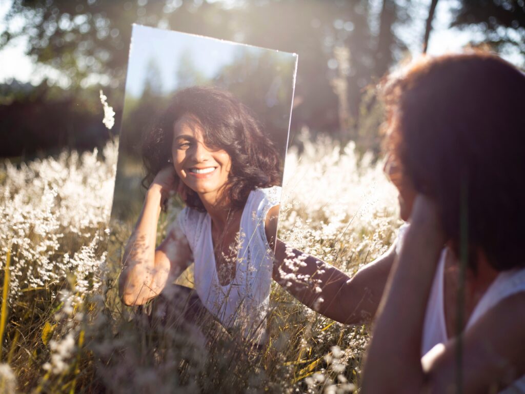 woman looks at her reflection with love