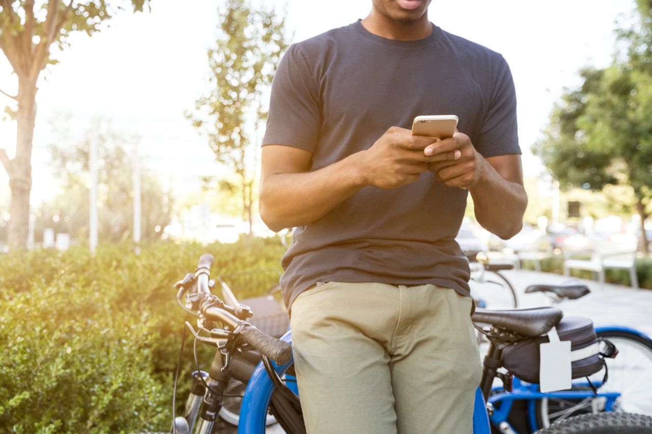 man responds to text message while outside on his bike