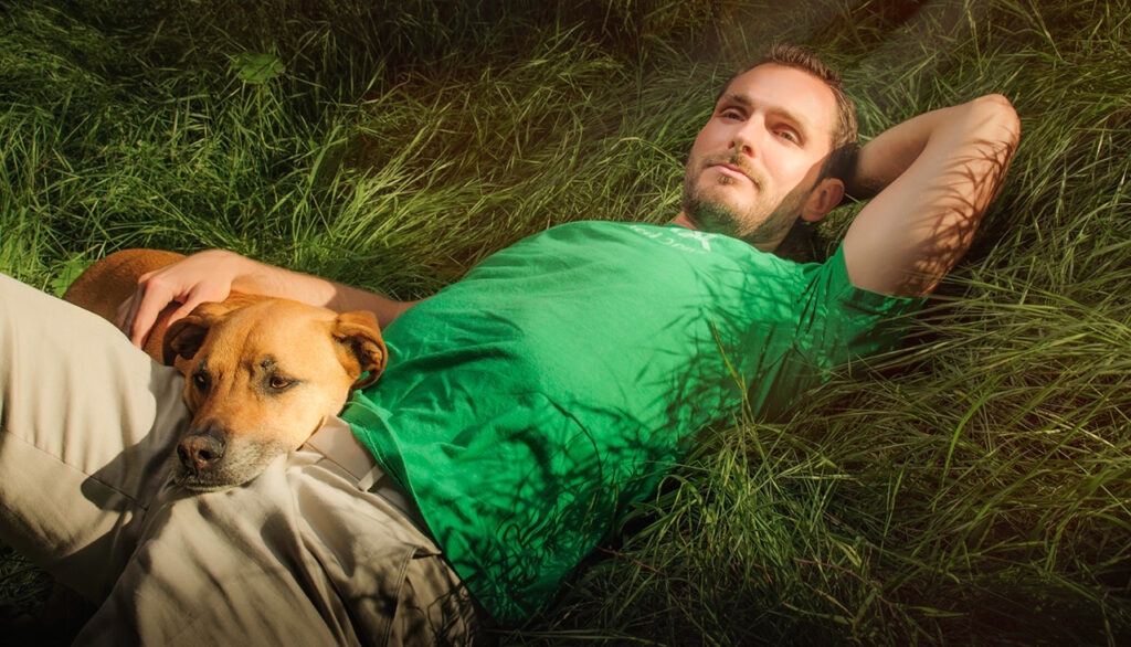 Homo Money relaxing in the grass with his baby puppy